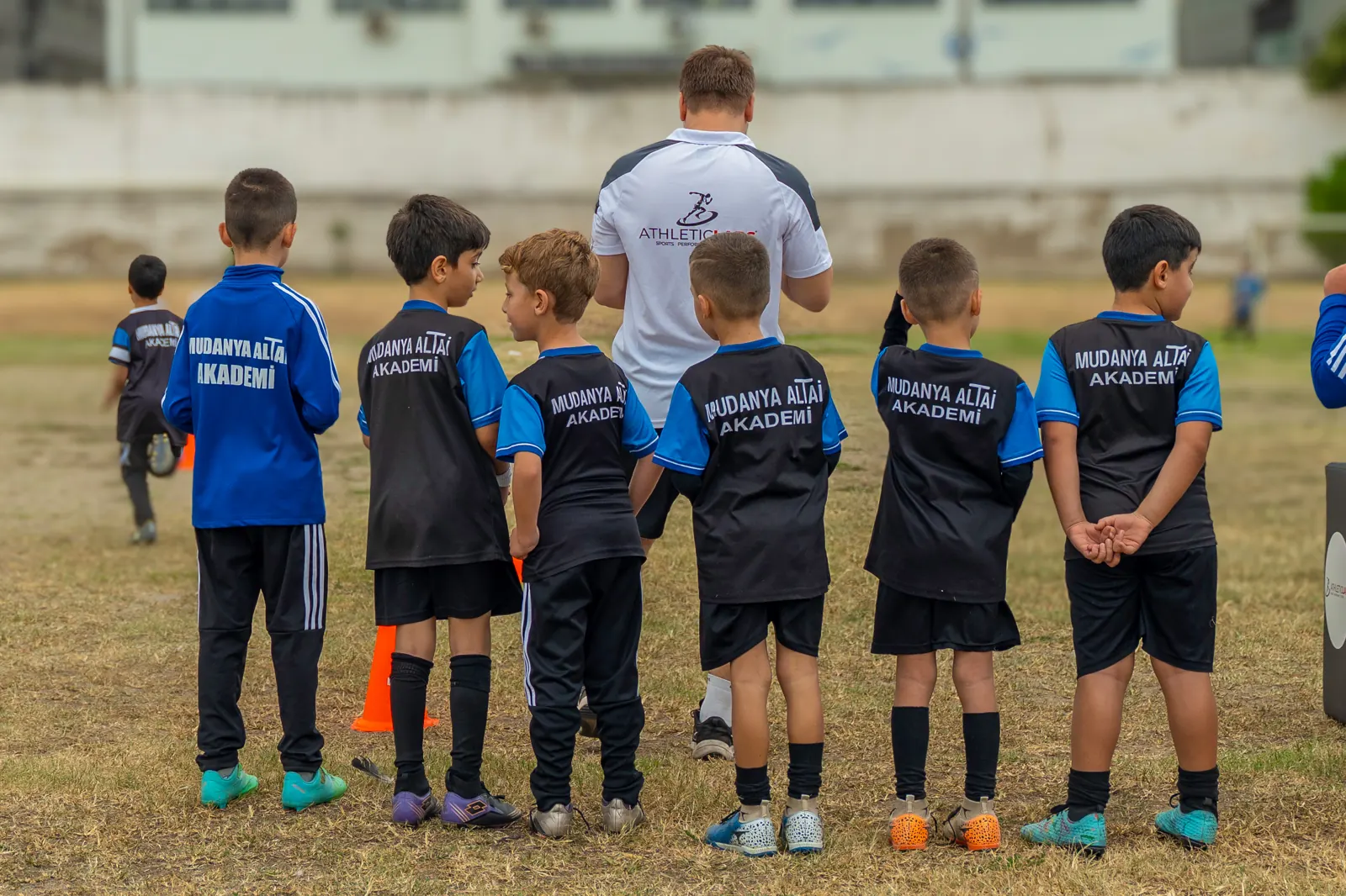 Sahada sıraya girmiş genç sporcular ve Athletic Labs antrenörü